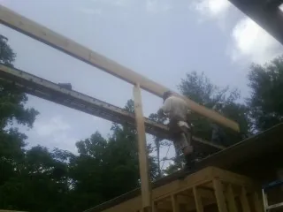 Carpenter setting a ridge beam over a new addition frame — Ice Dam Removal by Roofing Brothers in Lake Ozark