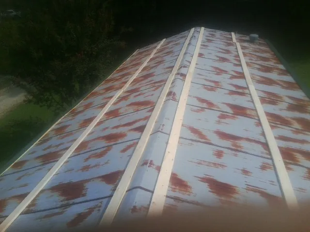 Rusted metal roof panels with new wood purlins before replacement — Storm Damage Roof Repair in Lake Ozark by Roofing Brothers