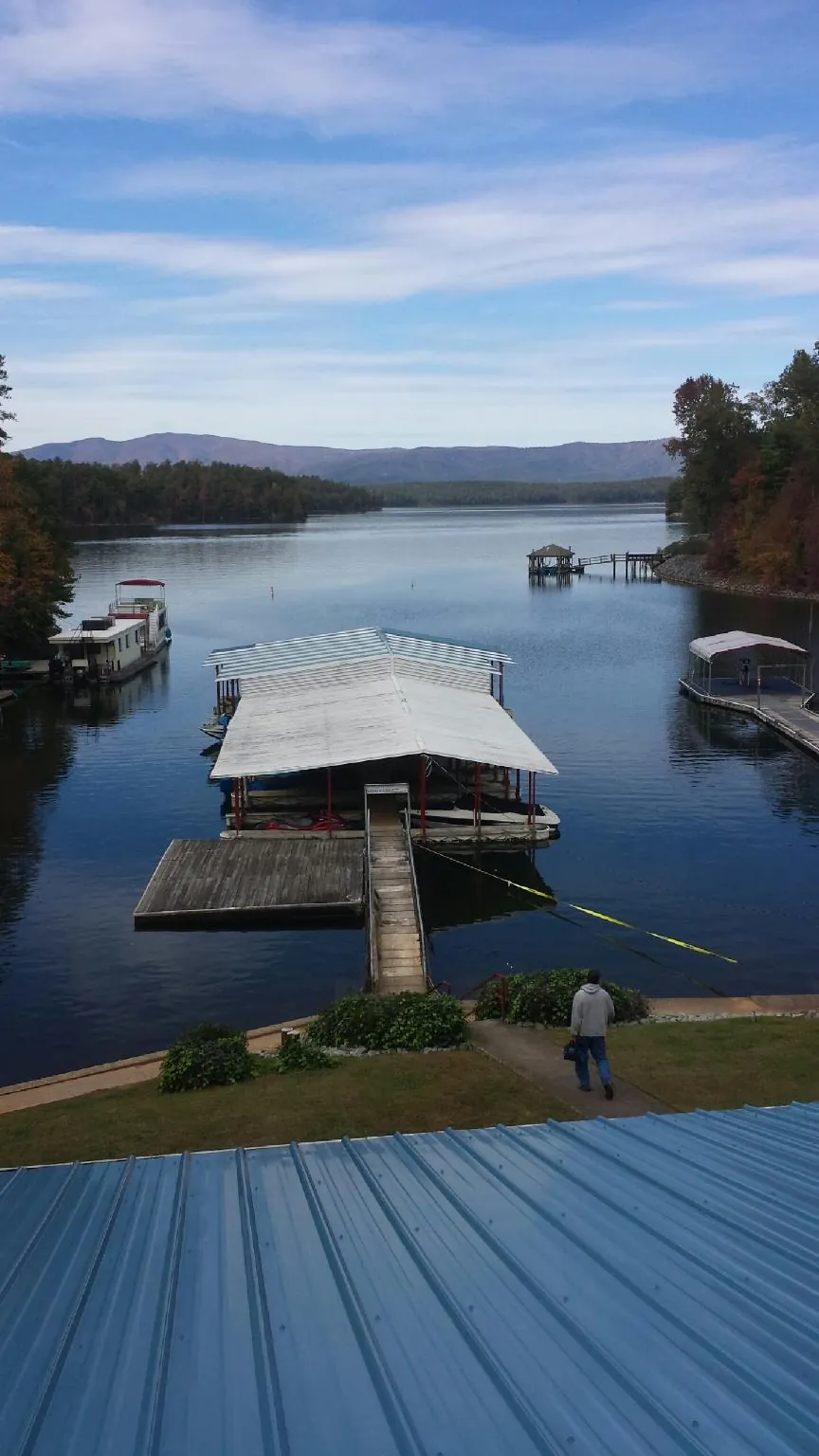 View across a lake from a newly installed blue metal roof in Lake Ozark