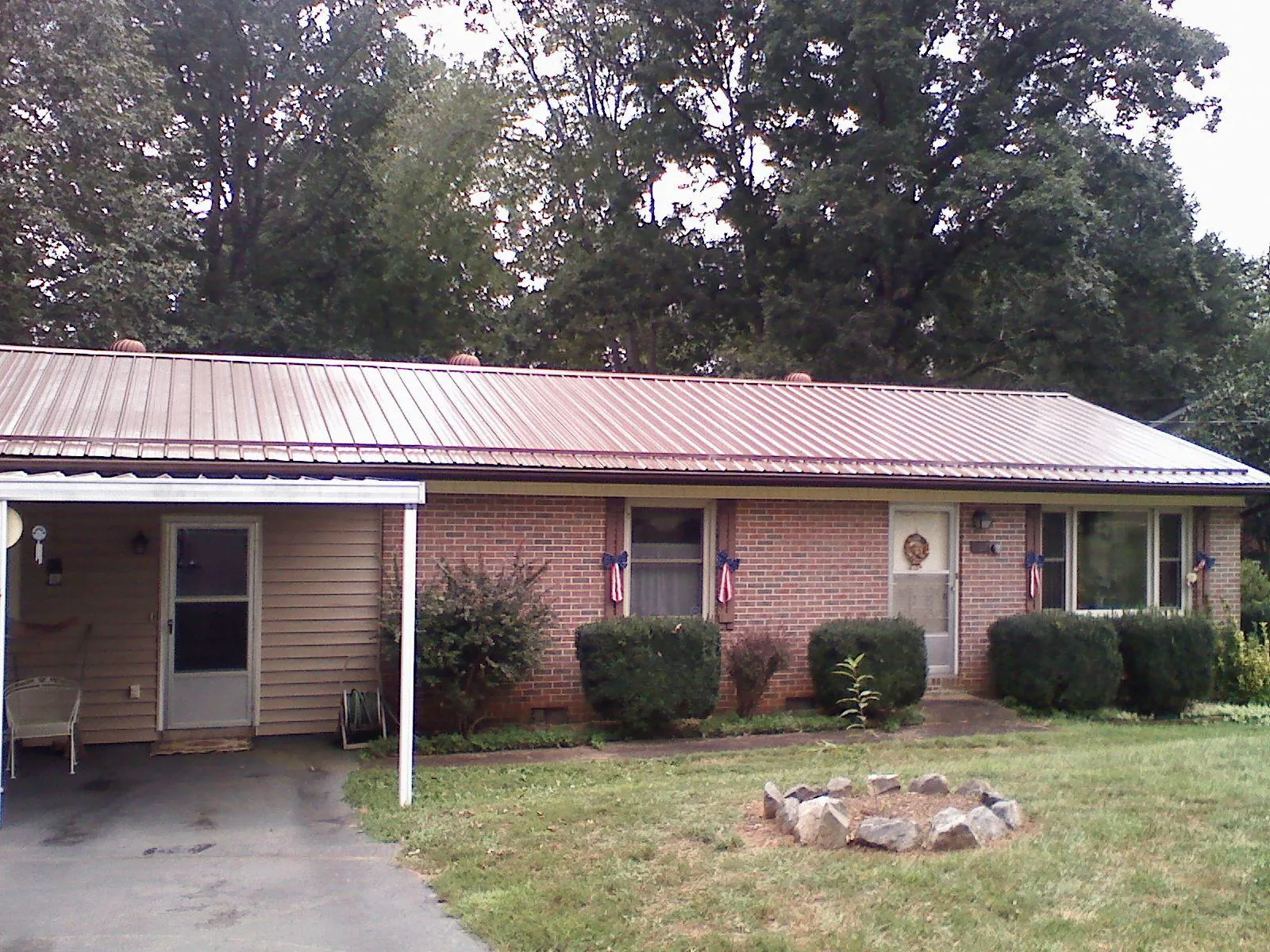 Bronze metal roof and carport on a brick ranch home — Roof Repair work by our crew in Lake Ozark