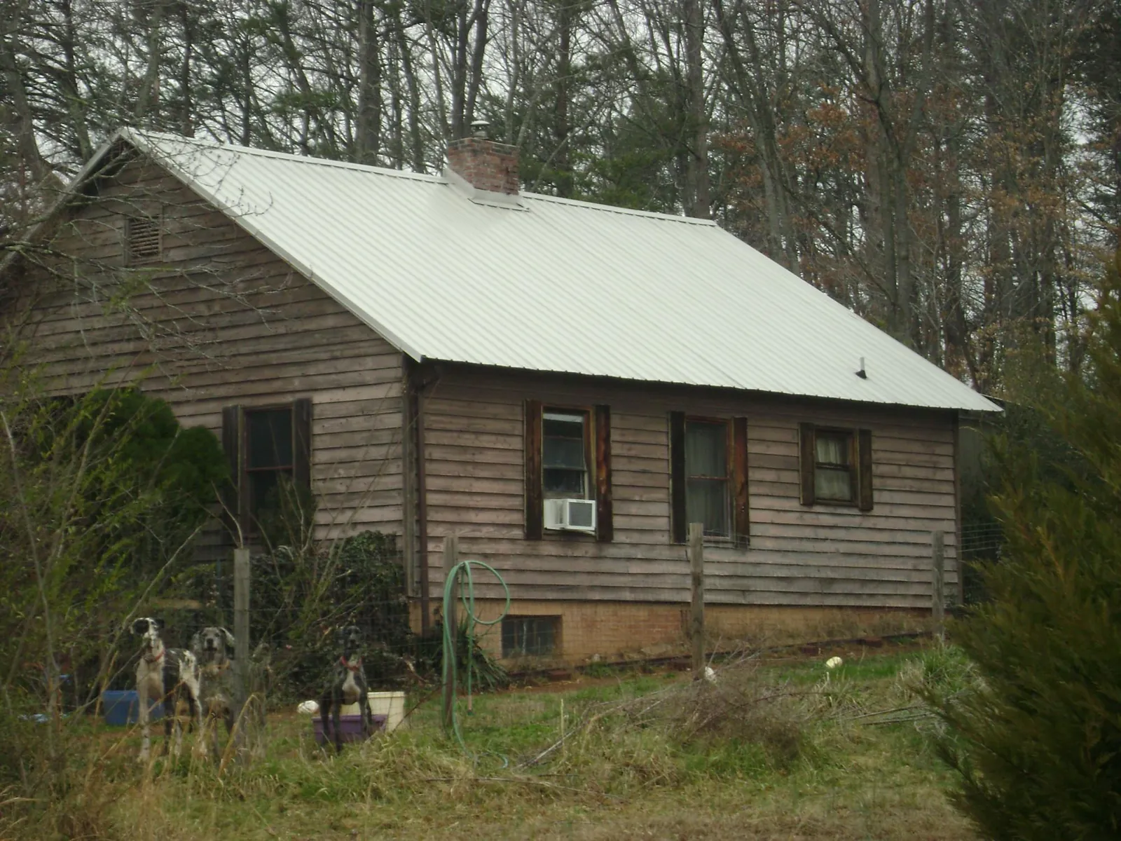 White metal roof on an old wood sided farmhouse, from a Metal Roof Installation job in Lake Ozark